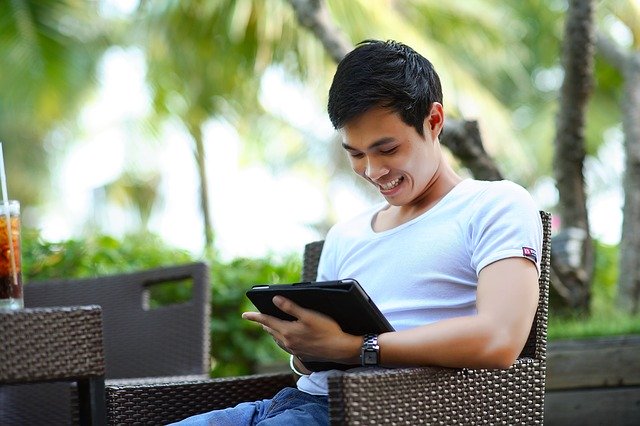 man smiling at tablet
