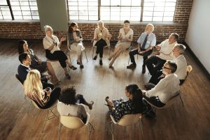 A group of people sitting in chairs arranged in a circle