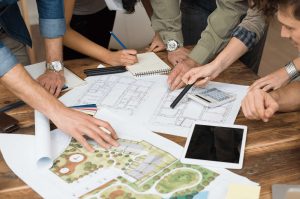 A group of people gathered around a table reviewing blueprints