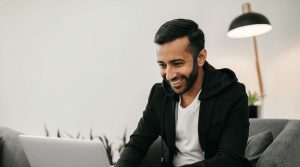 A man sitting on a sofa using a laptop computer