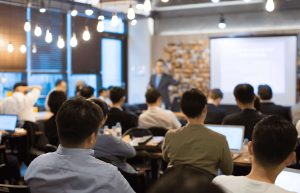 A room of people watching a man give a presentation